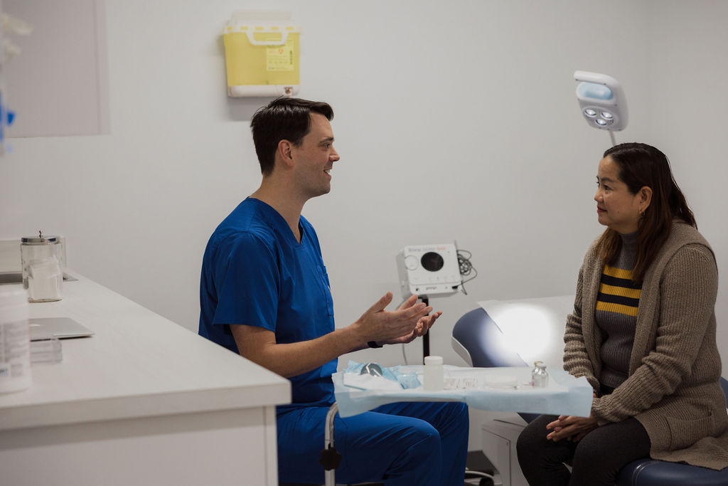Doctor talking with a patient. Both are smiling.